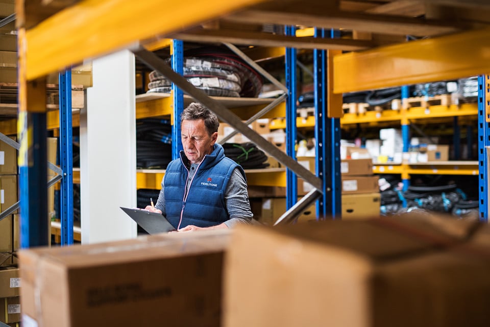 FIDELITONE employee checking inventory to reduce warehouse costs