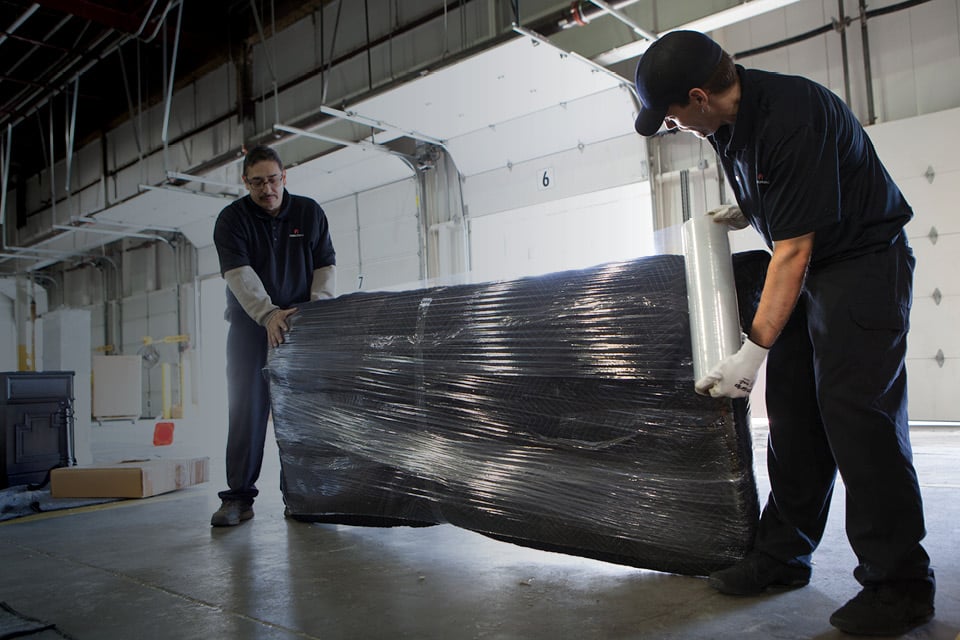 FIDELITONE workers wrapping couch for last mile delivery